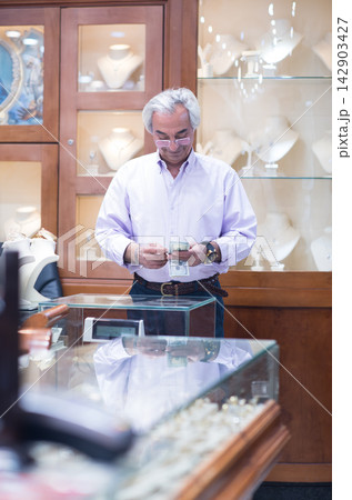 Middle Eastern couple buying wedding ring in a jewelry store with family and friends present Middle Eastern couple buying wedding ring in a jewelry store with family and friends present 142903427