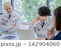 ミーティングで考える作業着のベテランと若手 142904060