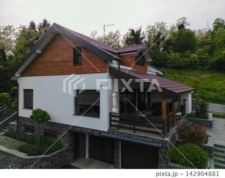 Modern two-story house with covered terrace and landscaped garden in a quiet suburban setting Modern two-story house with covered terrace and landscaped garden in a quiet suburban setting 142904881