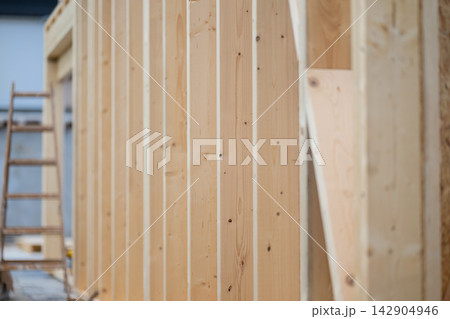 New wood frame construction wall with vertical studs and ladder at residential building site New wood frame construction wall with vertical studs and ladder at residential building site 142904946