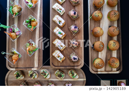Overhead view of assorted bite-size desserts and berry parfaits on a catering buffet tray 142905189