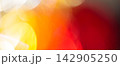 Abstract blurred background with overlapping golden bokeh and a deep red gradient 142905250