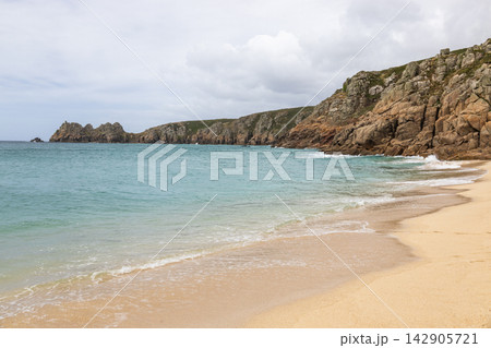 Sandy beach and turquoise sea by coastal cliffs Sandy beach and turquoise sea by coastal cliffs 142905721