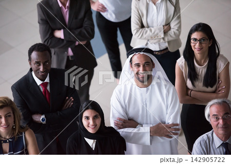 Diverse multinational business team smiling and confident in a modern corporate office setting Diverse multinational business team smiling and confident in a modern corporate office setting 142905722