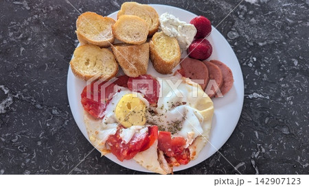 Fried eggs with tomato and baguette toast on a plate Fried eggs with tomato and baguette toast on a plate 142907123