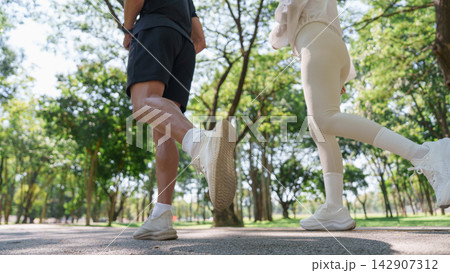 Cropped view of active couple jogging together in park for outdoor workout 142907312