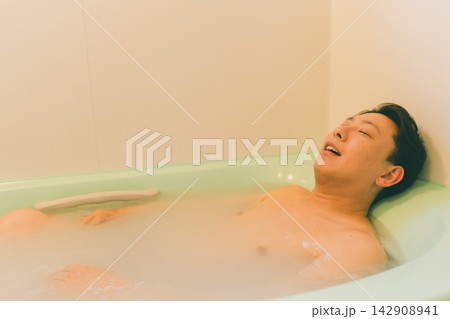 湯船でリラックスして目を閉じるアラフォー男性 142908941