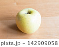 木のテーブルの上に置かれた黄色いリンゴ 142909058