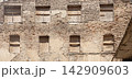 Old brick building facade with boarded up windows 142909603
