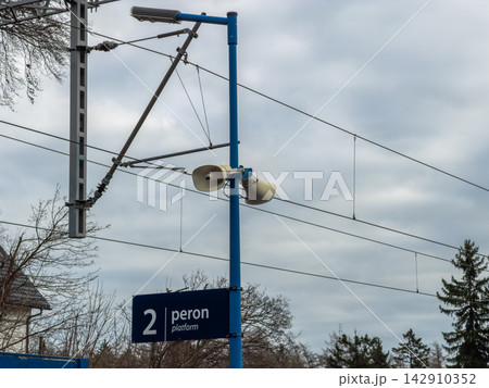 A blue pillar at a railway station features loud megaphones and a sign indicating platform two, highlighting essential transit infrastructure for passenger communication and safety 142910352