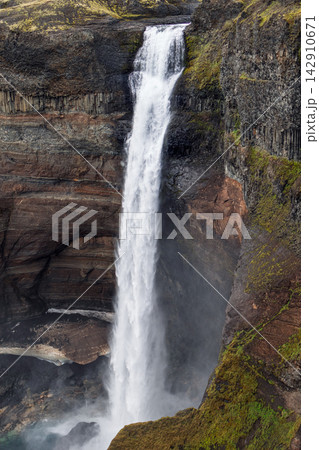 Haifoss waterfall beside basalt columns and a mossy canyon ledge in Iceland Haifoss waterfall beside basalt columns and a mossy canyon ledge in Iceland 142910671