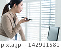 Young Businesswoman Working at Office Desk While Managing Documents and Mobile Communication. 142911581