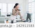 Young Businesswoman Working at Office Desk While Managing Documents and Mobile Communication. 142911583