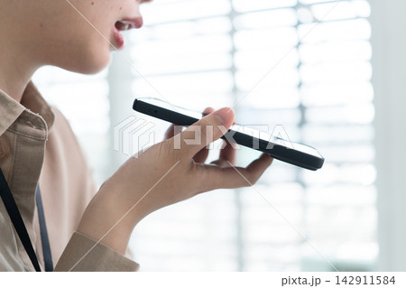 Young Businesswoman Working at Office Desk While Managing Documents and Mobile Communication. Young Businesswoman Working at Office Desk While Managing Documents and Mobile Communication. 142911584