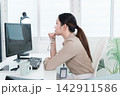 Young Businesswoman Working at Office Desk While Managing Documents and Mobile Communication. 142911586