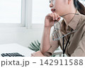 Young Businesswoman Working at Office Desk While Managing Documents and Mobile Communication. 142911588