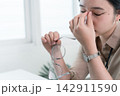 Young Businesswoman Working at Office Desk While Managing Documents and Mobile Communication. 142911590