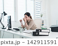 Young Businesswoman Working at Office Desk While Managing Documents and Mobile Communication. 142911591