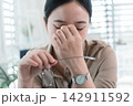 Young Businesswoman Working at Office Desk While Managing Documents and Mobile Communication. 142911592