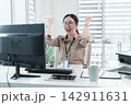 Young Businesswoman Working at Office Desk While Managing Documents and Mobile Communication. 142911631