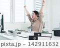 Young Businesswoman Working at Office Desk While Managing Documents and Mobile Communication. 142911632