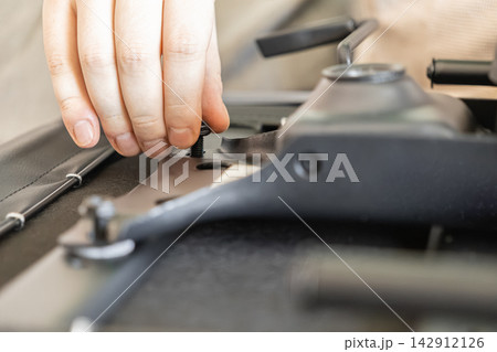 A hand inserts a small metal screw into the mechanism of an office chair during assembly, illustrating manual furniture construction and home improvement tasks in a modern workspace A hand inserts a small metal screw into the mechanism of an office chair during assembly, illustrating manual furniture construction and home improvement tasks in a modern workspace 142912126