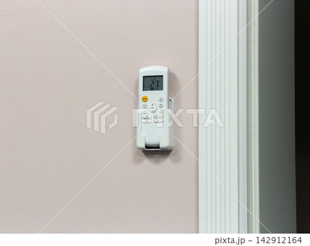 An electronic climate controller sits inside a sleek wall holder, displaying a digital setting to provide seamless regulation of interior heat or cooling for enhanced living comfort An electronic climate controller sits inside a sleek wall holder, displaying a digital setting to provide seamless regulation of interior heat or cooling for enhanced living comfort 142912164