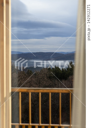 A serene foggy forest landscape viewed from a cozy indoor balcony, capturing the calm beauty of misty mountains and wild evergreen trees during a quiet and peaceful winter morning A serene foggy forest landscape viewed from a cozy indoor balcony, capturing the calm beauty of misty mountains and wild evergreen trees during a quiet and peaceful winter morning 142912271