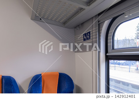 A priority seating sign inside a modern train carriage next to a bright window, representing accessible public transportation and inclusive travel infrastructure for all passengers A priority seating sign inside a modern train carriage next to a bright window, representing accessible public transportation and inclusive travel infrastructure for all passengers 142912401
