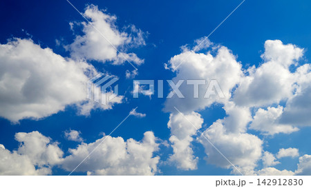white cumulus clouds scattered across the light blue sky on a sunny day white cumulus clouds scattered across the light blue sky on a sunny day 142912830