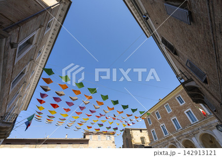 Colorful triangular flags are strung across a small square in Urbino, Italy Colorful triangular flags are strung across a small square in Urbino, Italy 142913121
