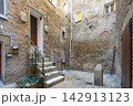 image shows a narrow courtyard with old brick buildings in Urbino, Italy 142913123