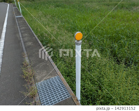 道路脇に設置された反射板付き視線誘導標と側溝 道路脇に設置された反射板付き視線誘導標と側溝 142913152