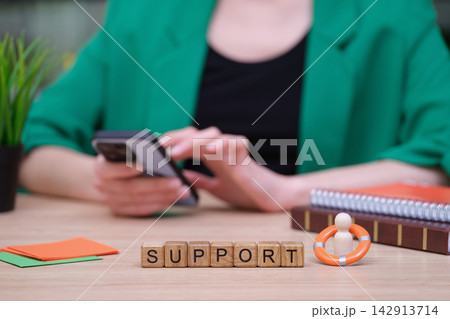 Support blocks amidst a busy workspace with a person engaged on their phone 142913714