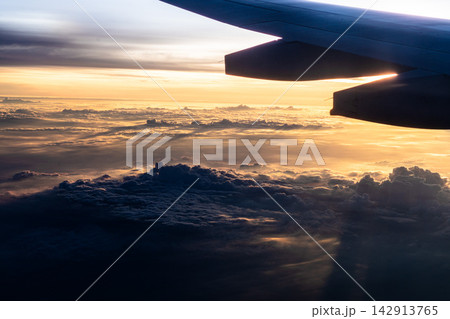 Stunning Aerial View of Clouds and Sky During Sunset from an Airplane Window: Capturing the Beauty of Nature from Above. Stunning Aerial View of Clouds and Sky During Sunset from an Airplane Window: Capturing the Beauty of Nature from Above. 142913765