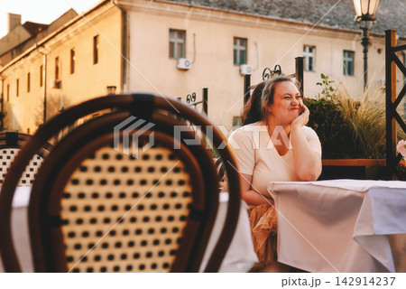 Carefree Woman Having Fun at Outdoor Cafe 142914237