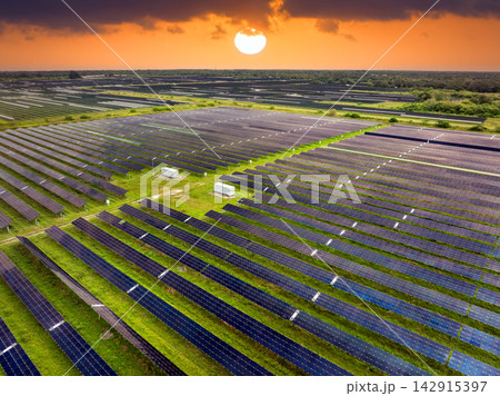 Aerial view of large sustainable electrical power plant with rows of solar photovoltaic panels for producing clean electric energy. Concept of renewable electricity with zero emission Aerial view of large sustainable electrical power plant with rows of solar photovoltaic panels for producing clean electric energy. Concept of renewable electricity with zero emission 142915397