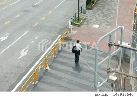 外回り営業で街を歩くサラリーマンの後ろ姿 都市の街並みと歩道のイメージ 外回り営業で街を歩くサラリーマンの後ろ姿 都市の街並みと歩道のイメージ 142915640