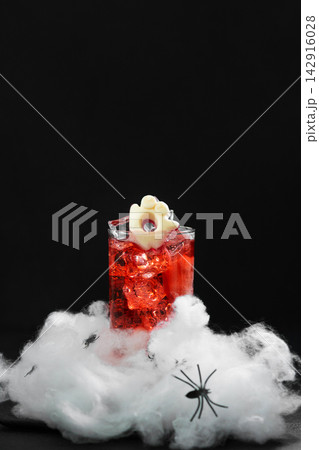 Spooky Halloween cocktail with ice and ghost decoration on cobweb Spooky Halloween cocktail with ice and ghost decoration on cobweb 142916028