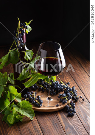Red Wine Bottle Glass Fresh Grapes Wooden Table Dark Background Studio Shot Red Wine Bottle Glass Fresh Grapes Wooden Table Dark Background Studio Shot 142916044