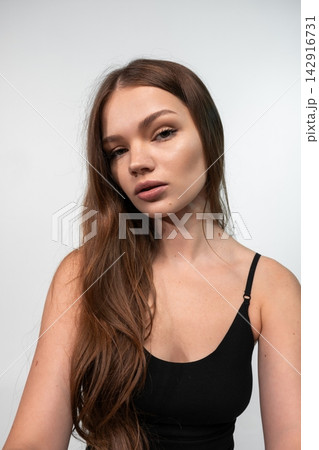 Young woman with natural beauty and long flowing hair looking at camera, showcasing healthy skin and lifestyle Young woman with natural beauty and long flowing hair looking at camera, showcasing healthy skin and lifestyle 142916731