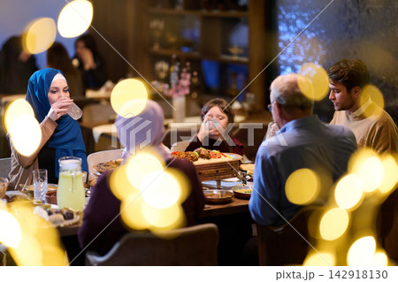 Multigenerational Family Dinner Celebration Together in Restaurant With Woman Wearing Hijab Multigenerational Family Dinner Celebration Together in Restaurant With Woman Wearing Hijab 142918130