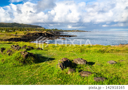 View of the volcanic coastline and green meadows at the Ahu Tahai archaeological site on Easter Island, Rapa Nui, Chile. 142918165