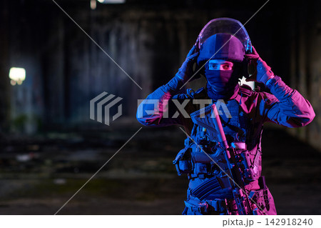 Tactical Soldier In Helmet And Body Armor Holding Rifle In Urban Night Operation With Colorful Lighting 142918240