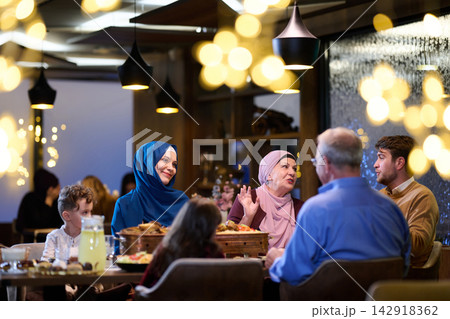 Muslim Family Dinner Celebrating Togetherness Across Generations In A Warm Restaurant Setting 142918362
