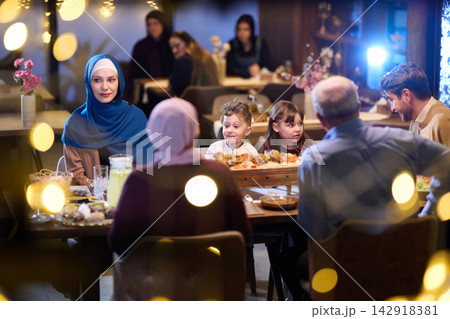 Multigenerational Muslim Family Sharing Warm Dinner Together At Festive Restaurant Gathering Multigenerational Muslim Family Sharing Warm Dinner Together At Festive Restaurant Gathering 142918381