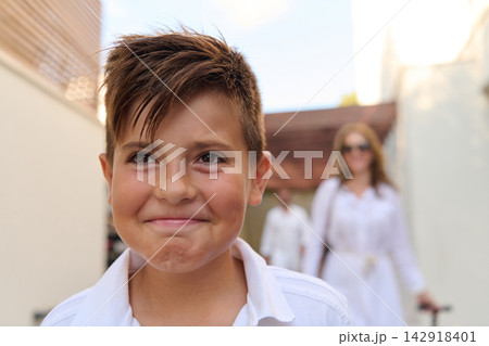Smiling Boy In Front Of Family During Summer Vacation Near Bicycle And Garage Smiling Boy In Front Of Family During Summer Vacation Near Bicycle And Garage 142918401