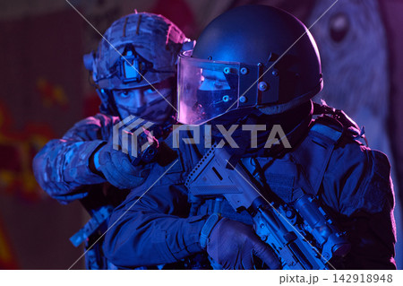 Tactical Soldiers In Night Raid Operation Wearing Helmets And Riot Visors With Assault Rifles 142918948