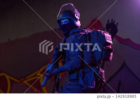 Tactical Medic Soldier In Night Urban Raid Wearing Helmet, Balaclava, Tactical Gear And Rifle 142918985