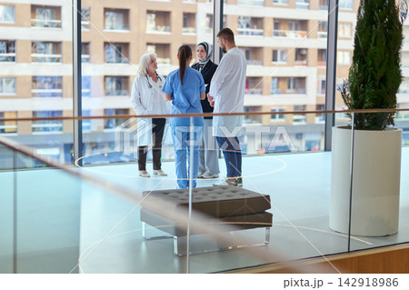 Medical team engages in discussion inside modern hospital during daylight hours 142918986